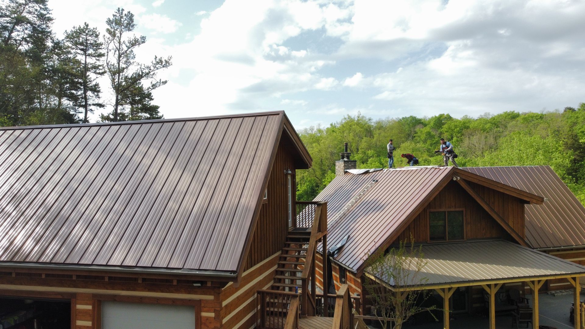 An aerial view of a log cabin with a metal roof.