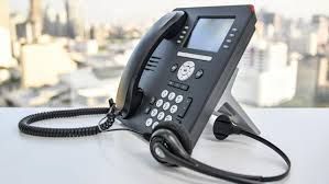 A telephone with a headset attached to it is sitting on a table.