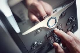 A person is pressing a button on a telephone.