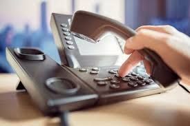 A person is pressing a button on a telephone.
