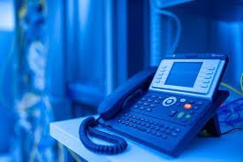 A telephone is sitting on a table in a blue room.