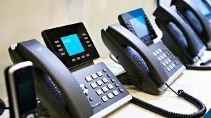 A row of telephones sitting on top of a table.