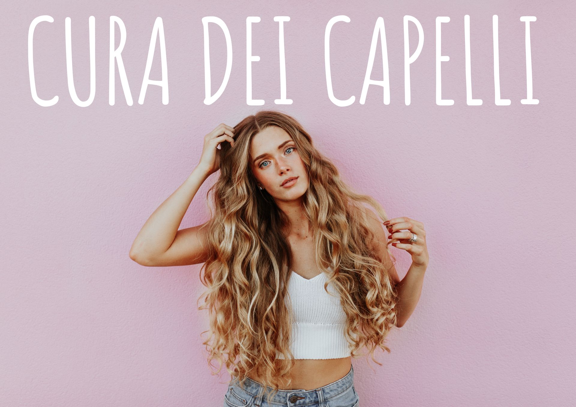 Una donna con i capelli lunghi è in piedi davanti a un muro rosa.