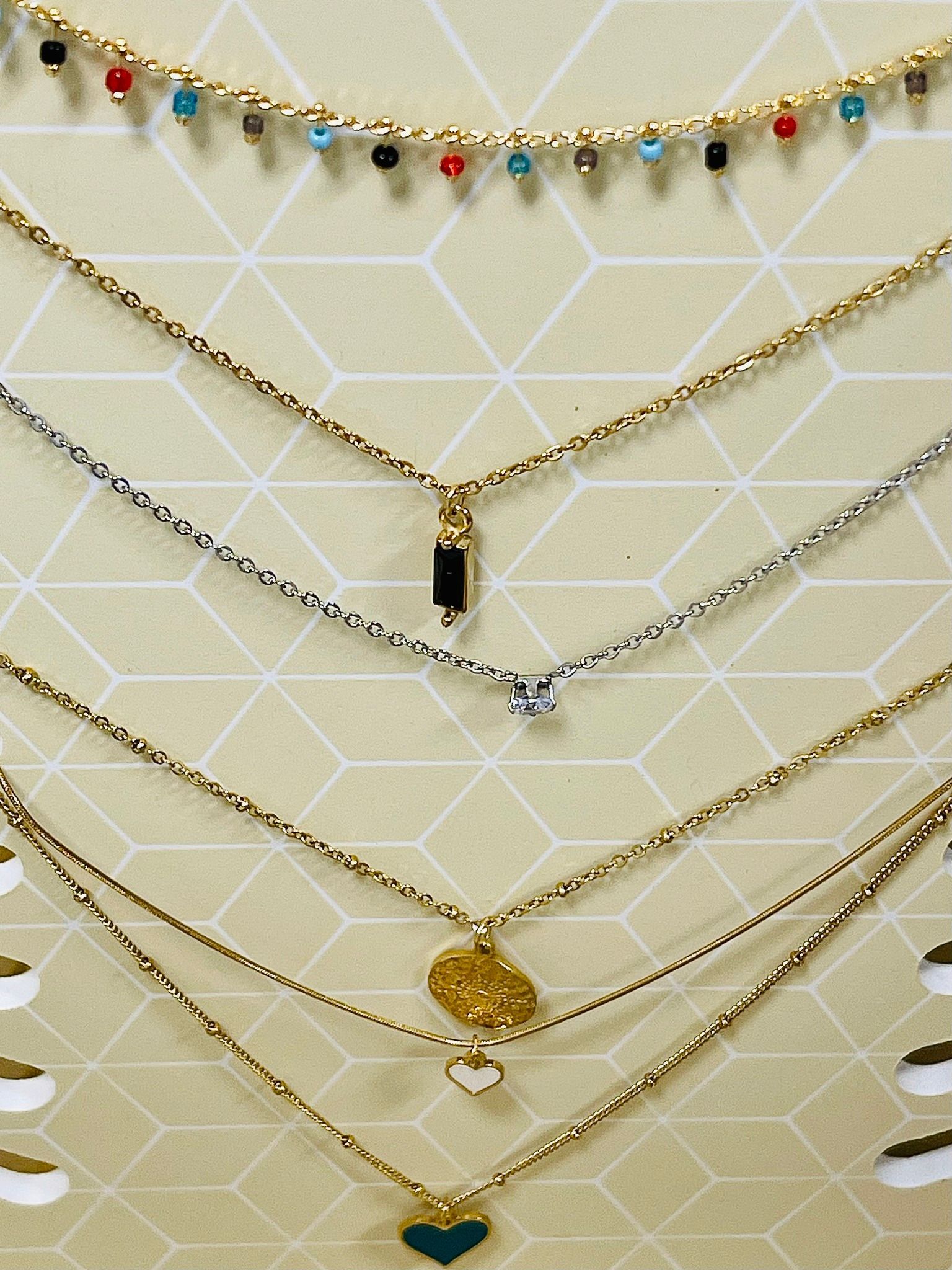 Un mazzo di collane è impilato uno sopra l'altro su un tavolo.