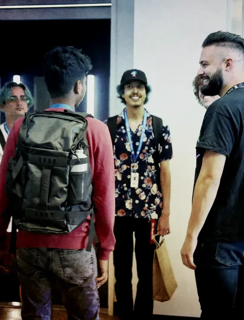 a group of men are standing in a hallway talking to each other