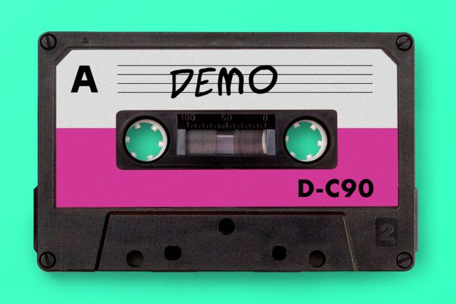 A pink and white cassette tape with demo written on it