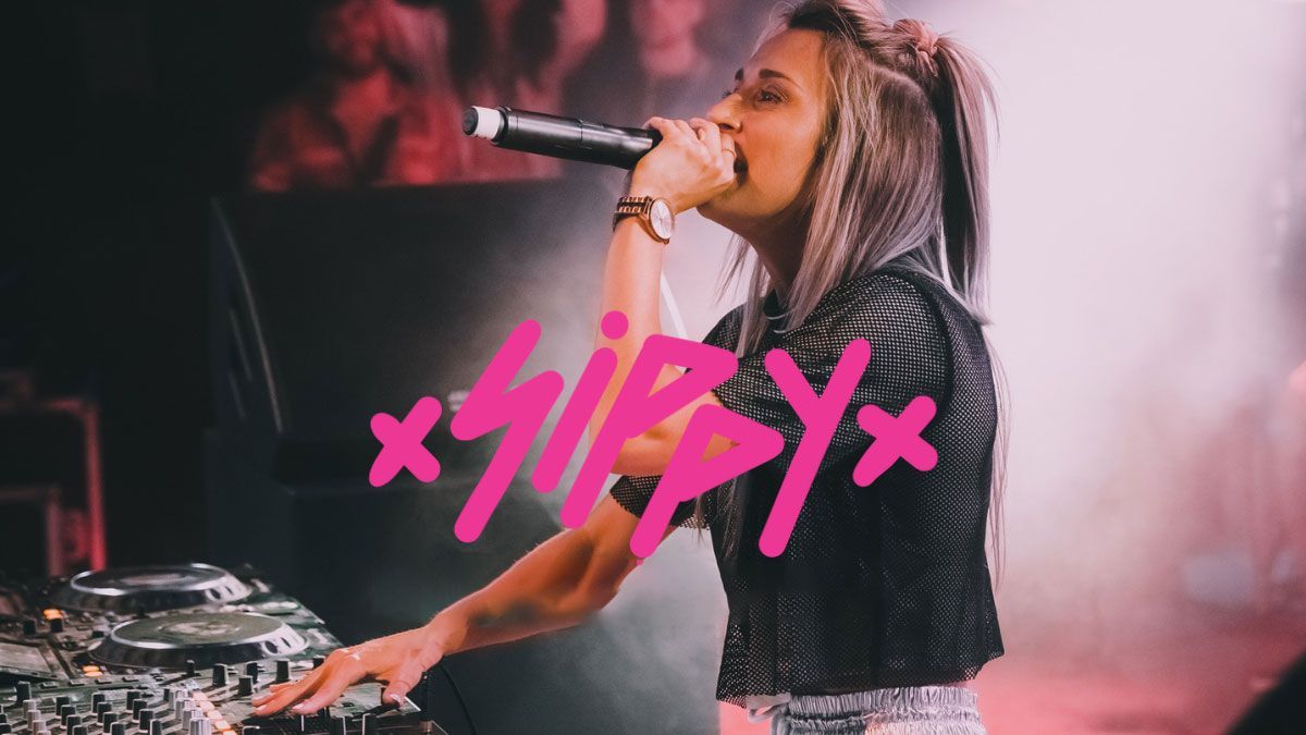 A woman is singing into a microphone on a stage.