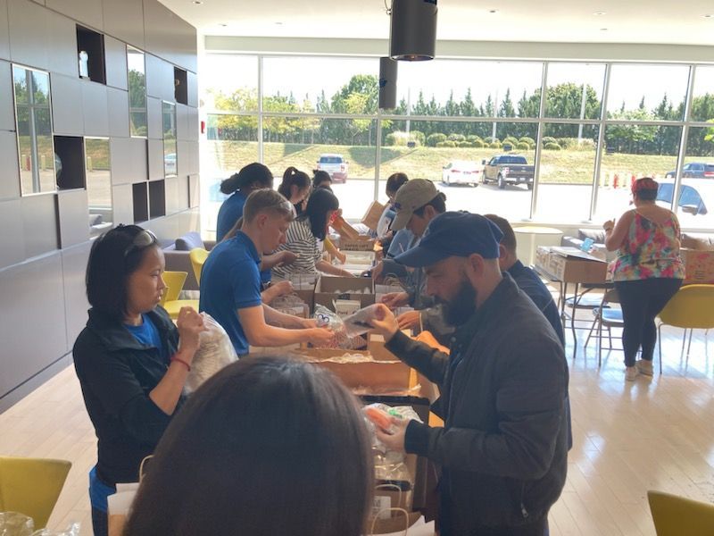Fuyao Glass Company employees assembling art kits for We Care Arts Transition To Work program.