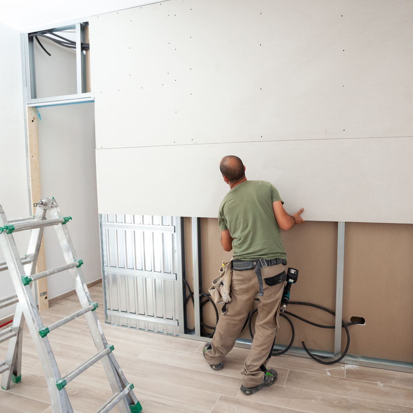 worker building plasterboard wall