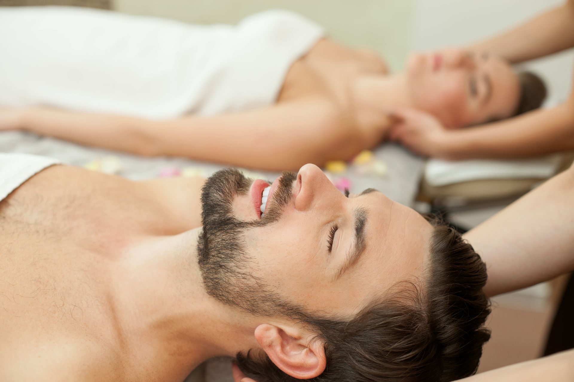 A woman with a towel wrapped around her head is getting a massage at a spa.