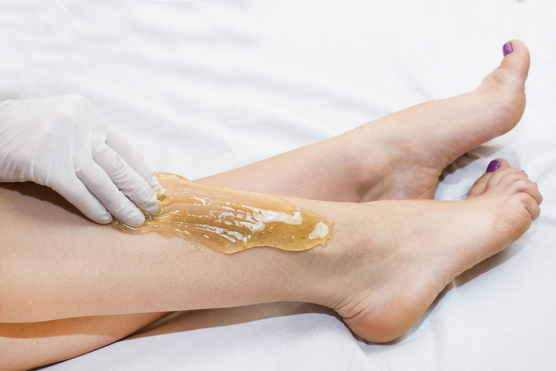 A woman is getting her legs waxed in a beauty salon.