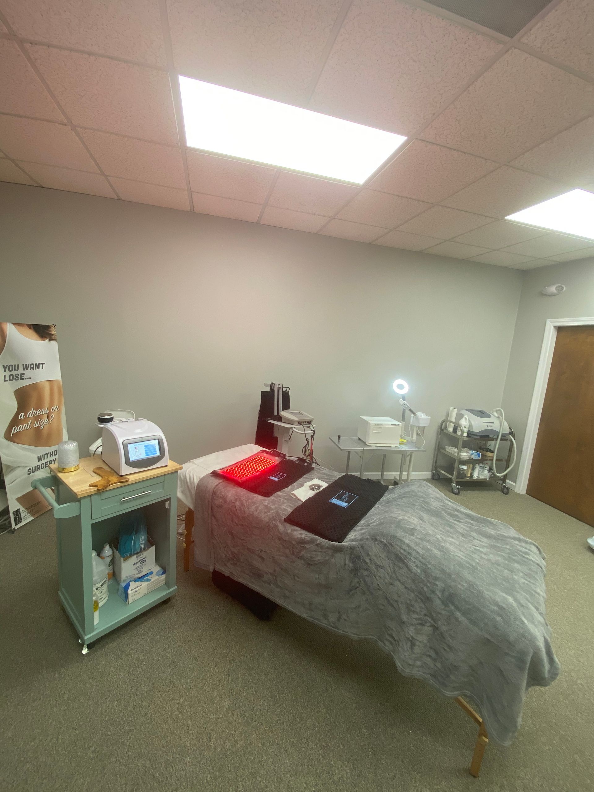 A room with a bed and a cart in it.