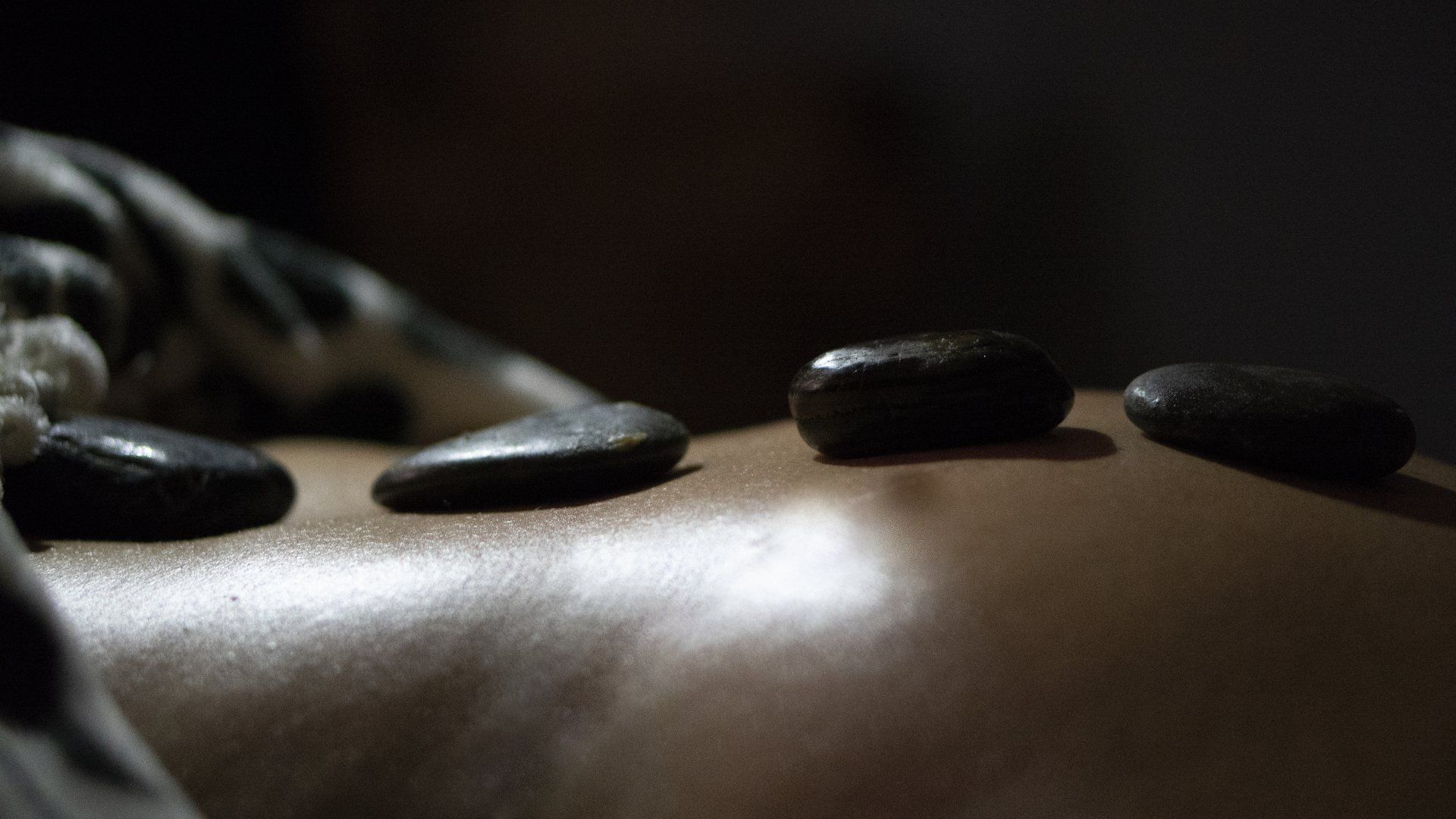 A person is getting a massage with hot rocks on their back.