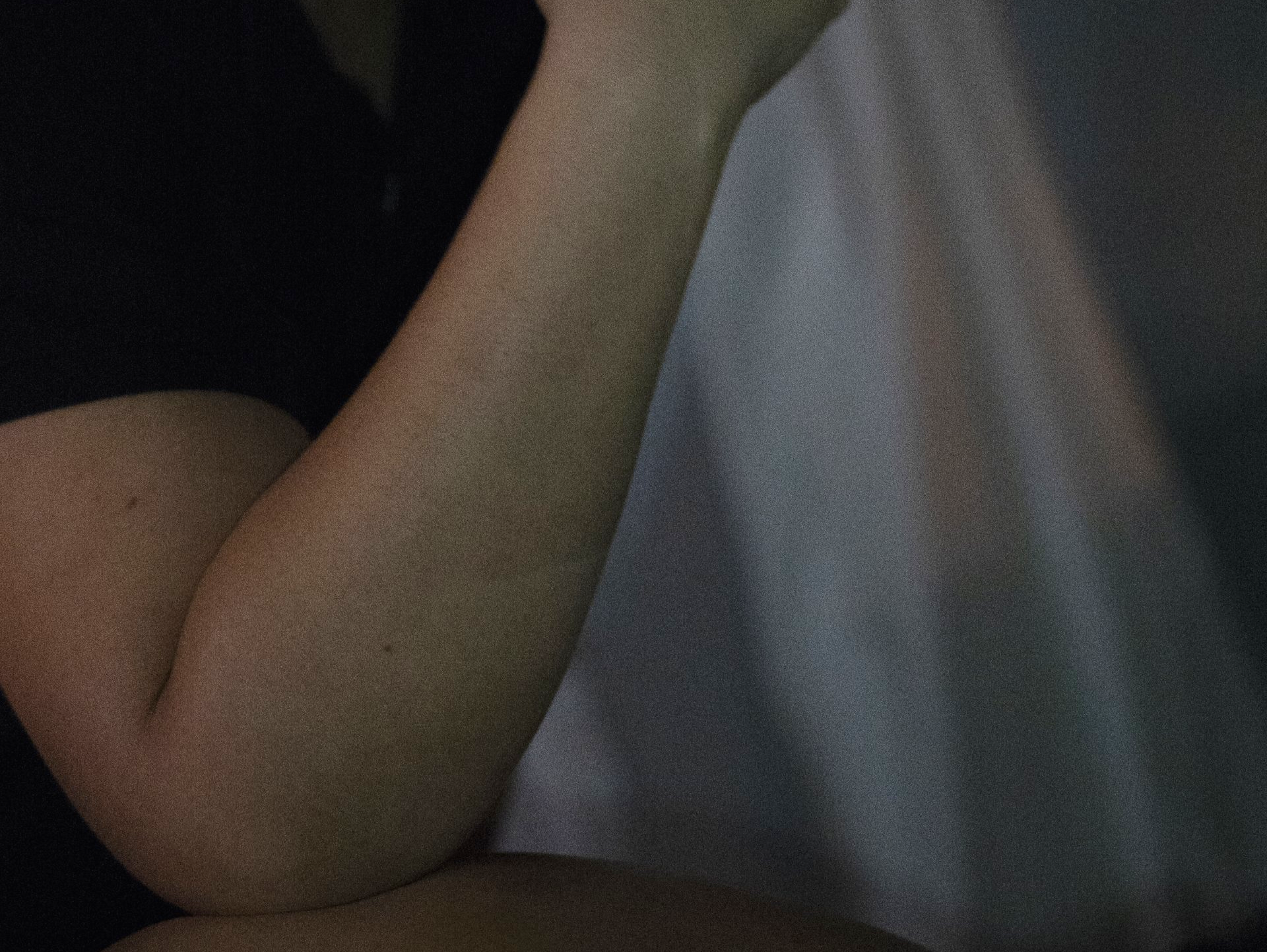 A close up of a person 's arm in a dark room.