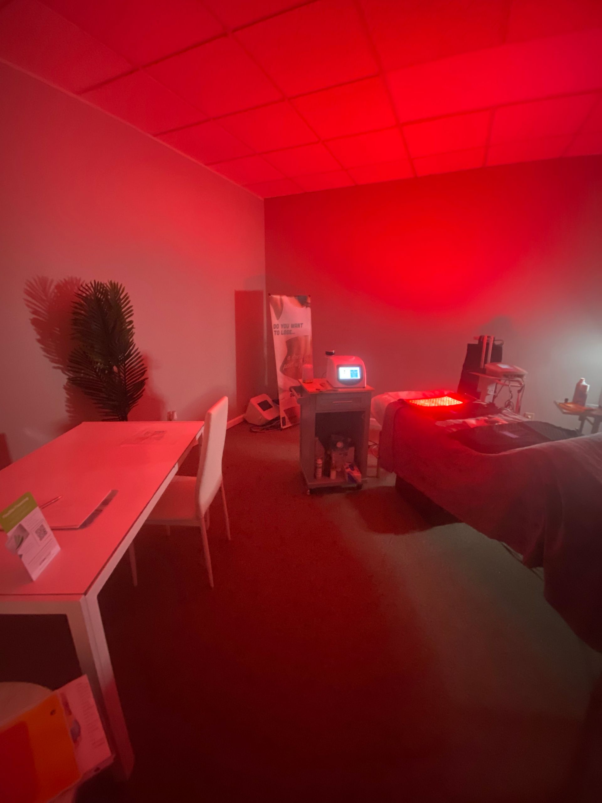 A living room with red lights on the ceiling and a table and chairs.