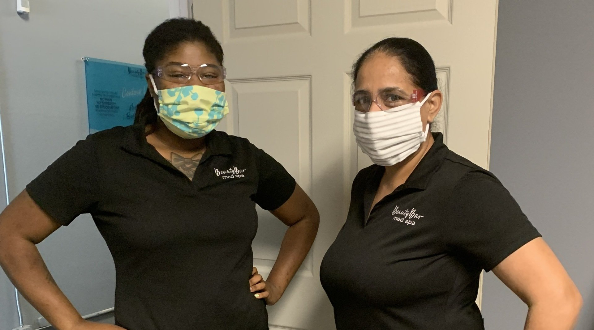 Two women wearing face masks are standing next to each other