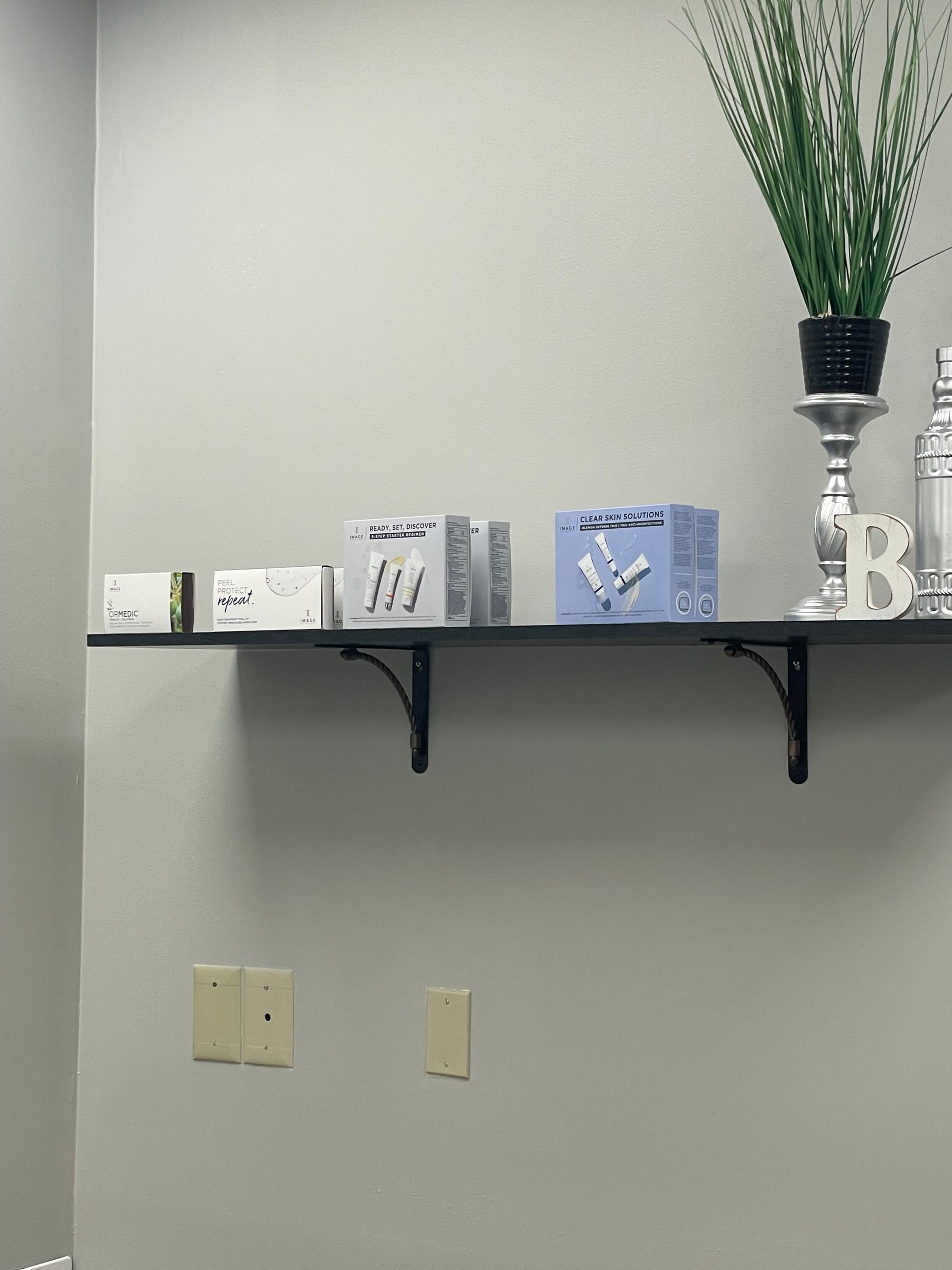 A shelf with a plant and candles on it