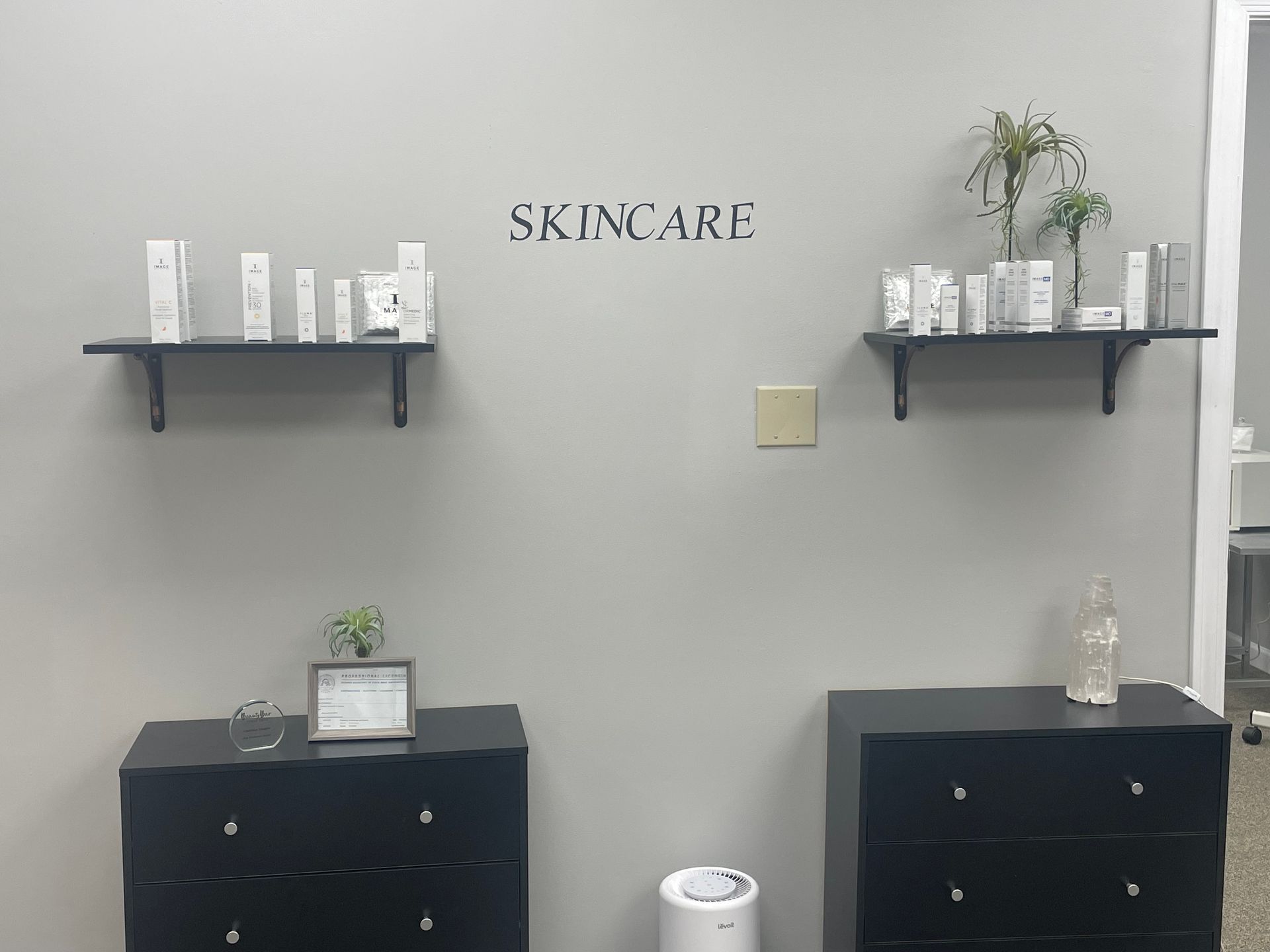 A room with two dressers and shelves with the word skincare on the wall.