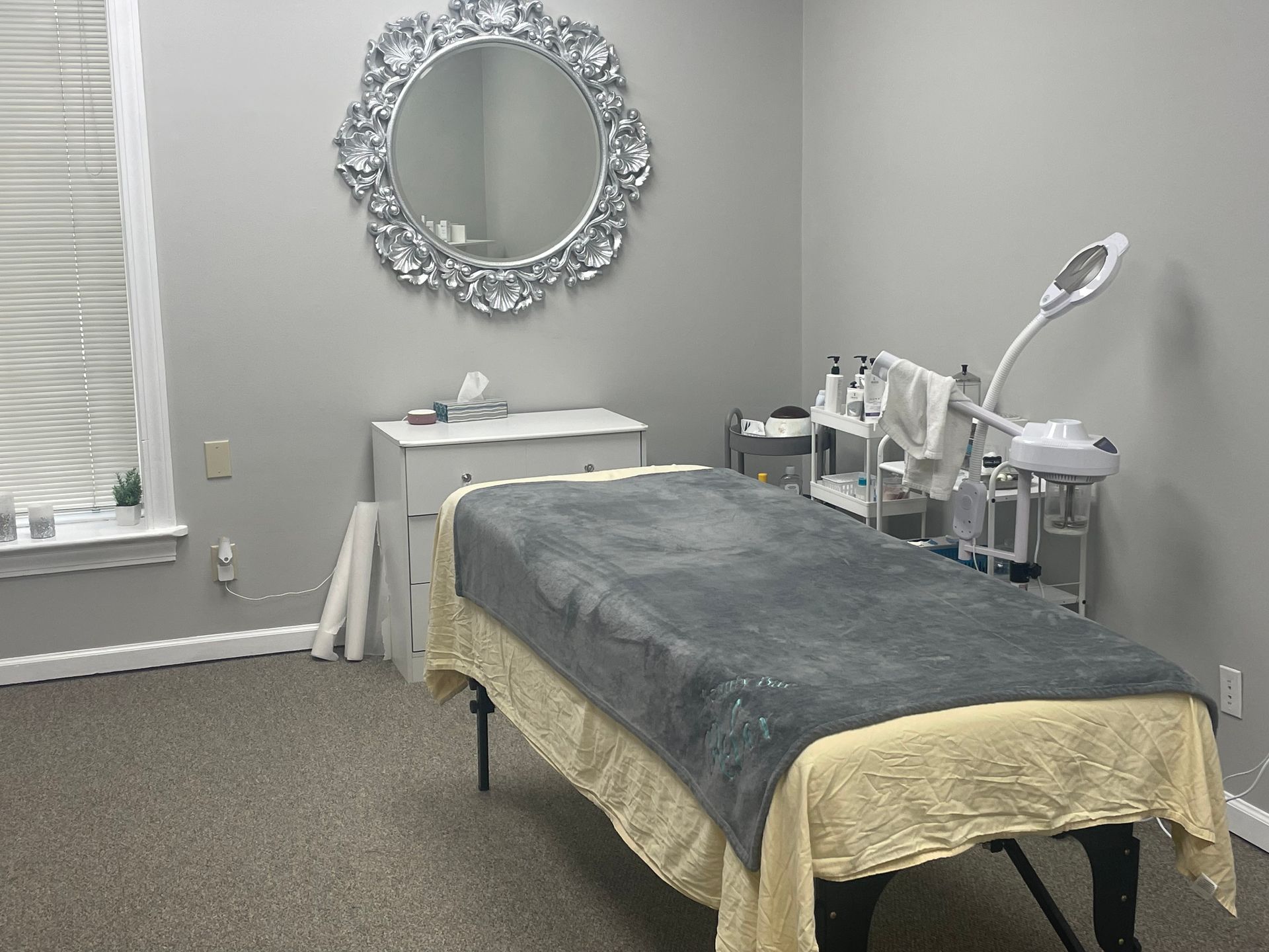 A massage table in a room with a mirror on the wall.