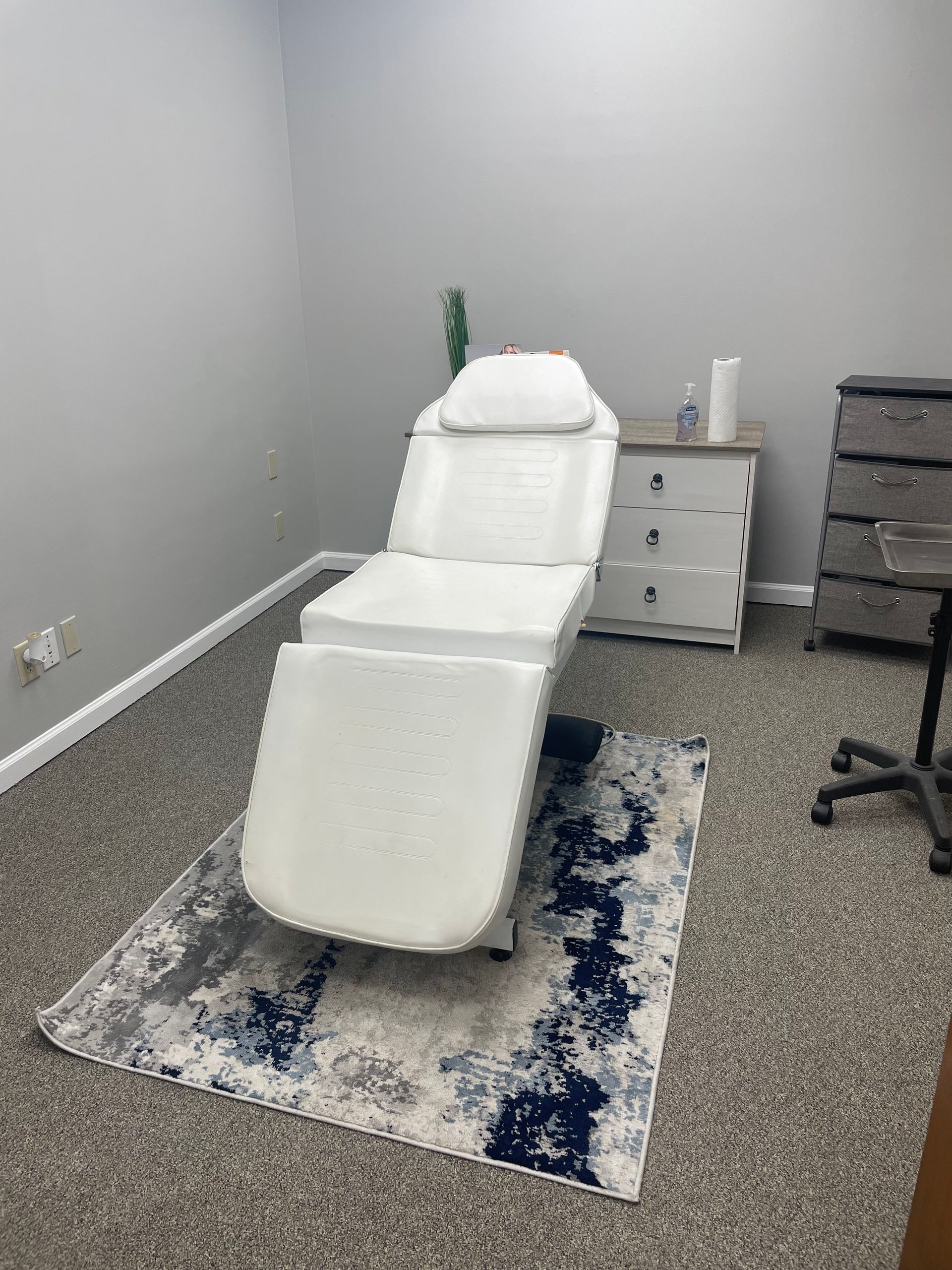 A white chair is sitting on a rug in a room.