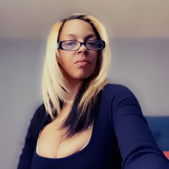 A woman wearing glasses and a black shirt is taking a selfie