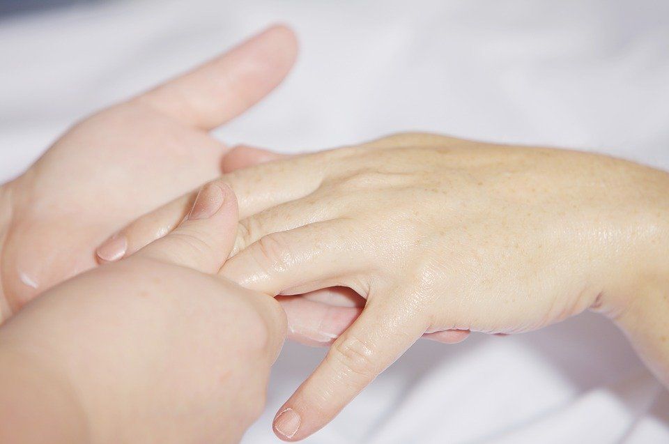 A close up of a person 's hand being massaged by another person.