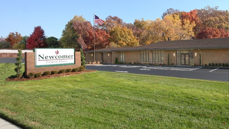 A large building with a sign in front of it that says newcomer