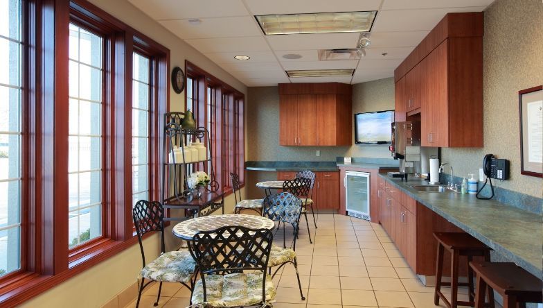 a room with tables and chairs and a picture on the wall .