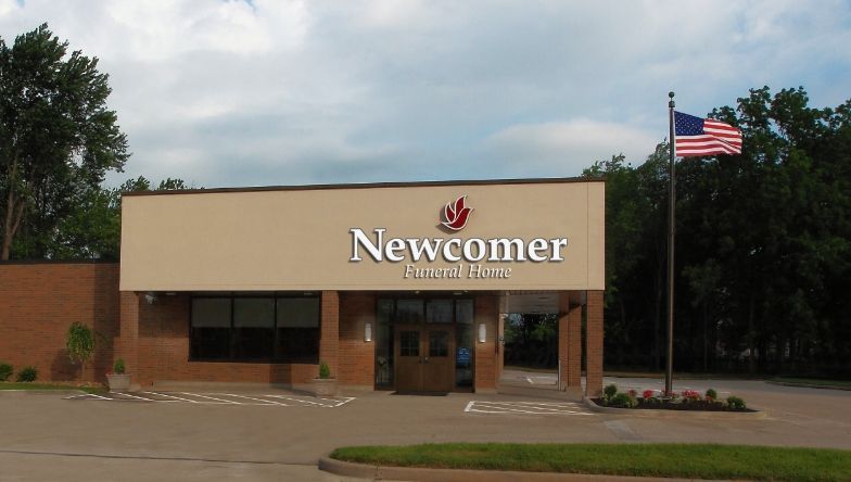 A newcomer funeral home with an american flag in front of it