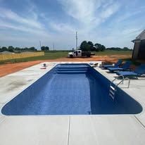 Newly built blue rectangular swimming pool in a sunny outdoor setting.