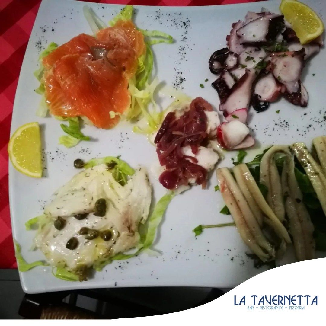 Piatto di antipasti di mare con salmone affumicato, polpo e pesce con capperi.