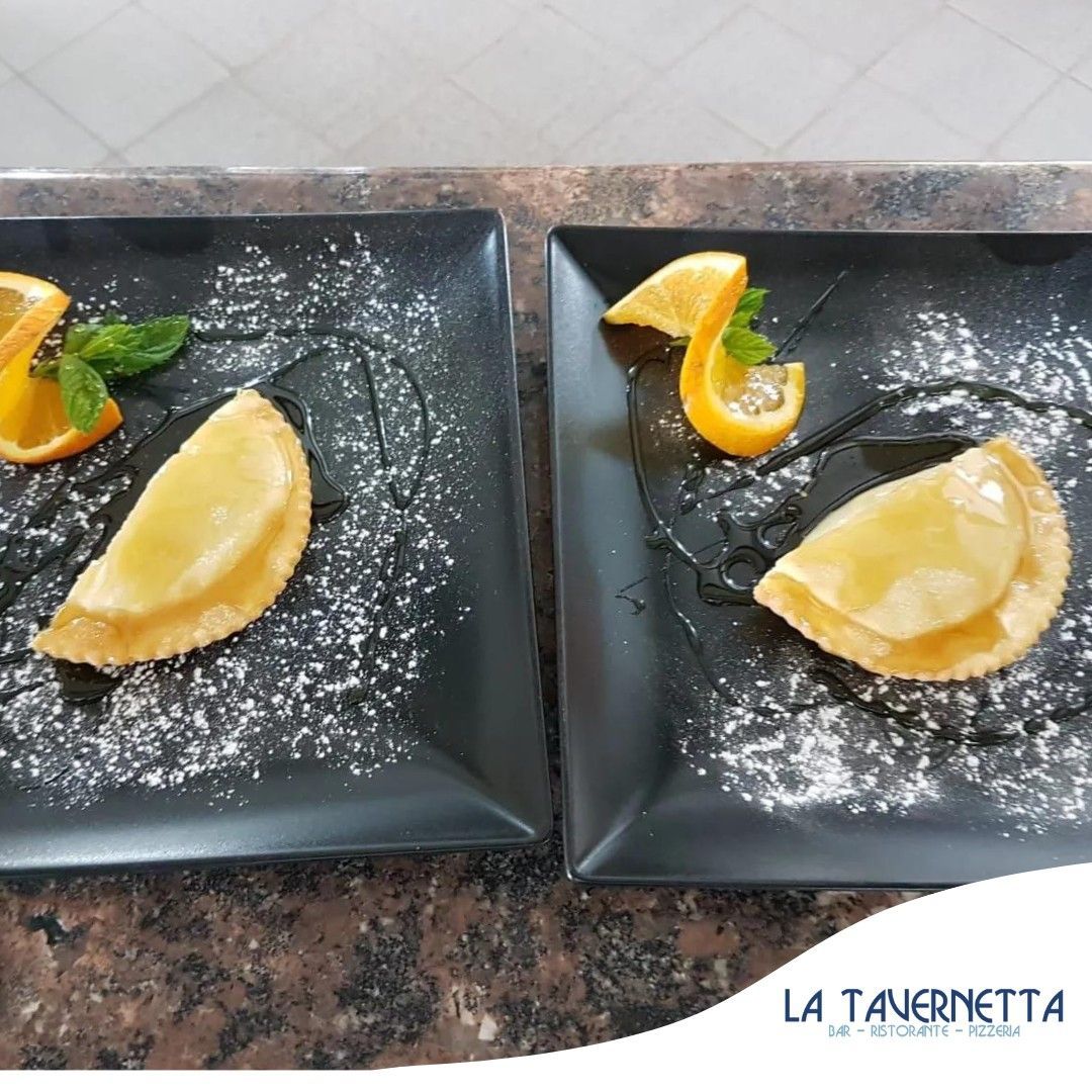 Due piatti di pasticcini fritti con fette d'arancia, spolverati di zucchero e ricoperti di cioccolato.