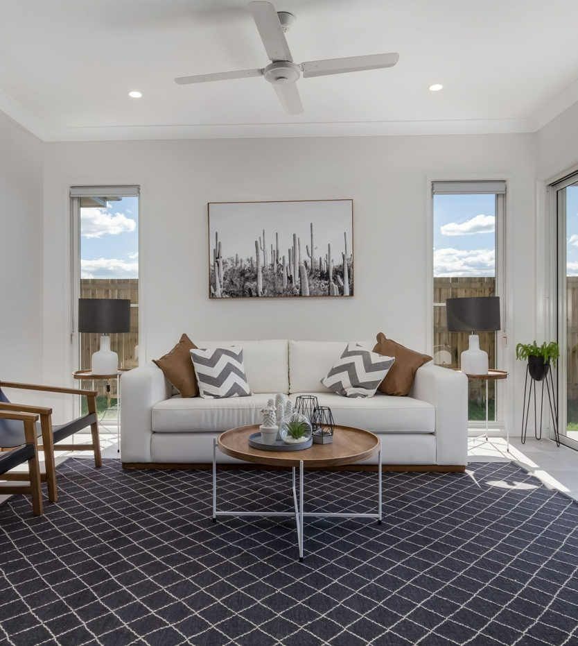 A Living Room With A White Couch And A Coffee Table — John McEwan Electrical In Dapto, NSW