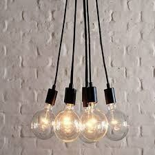 A Bunch of Light Bulbs Hanging From a Ceiling in Front of a White Brick Wall — John McEwan Electrical in Dapto, NSW