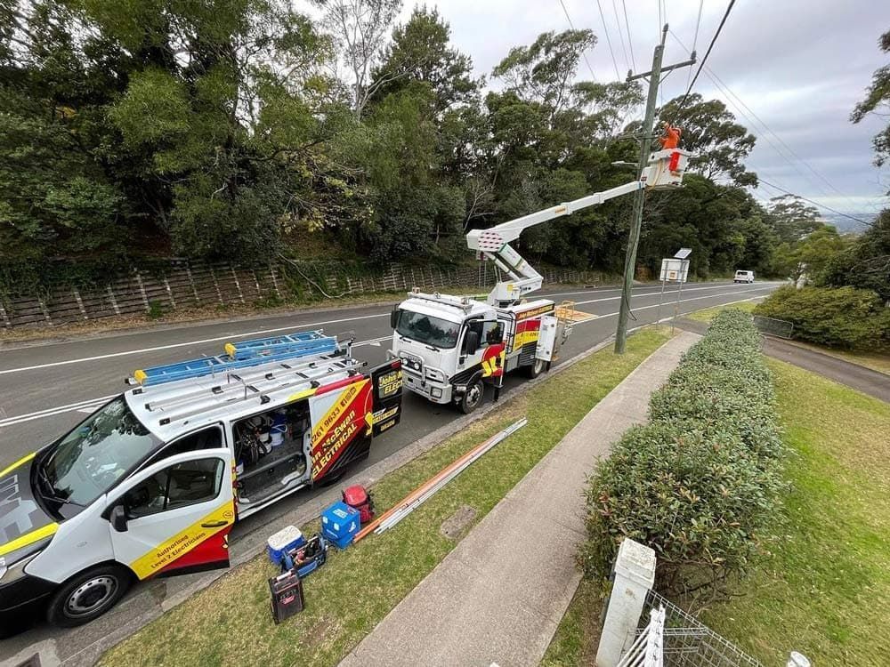 Vans Are Parked On The Side Of The Road Next To A Power Line — John McEwan Electrical In Dapto, NSW