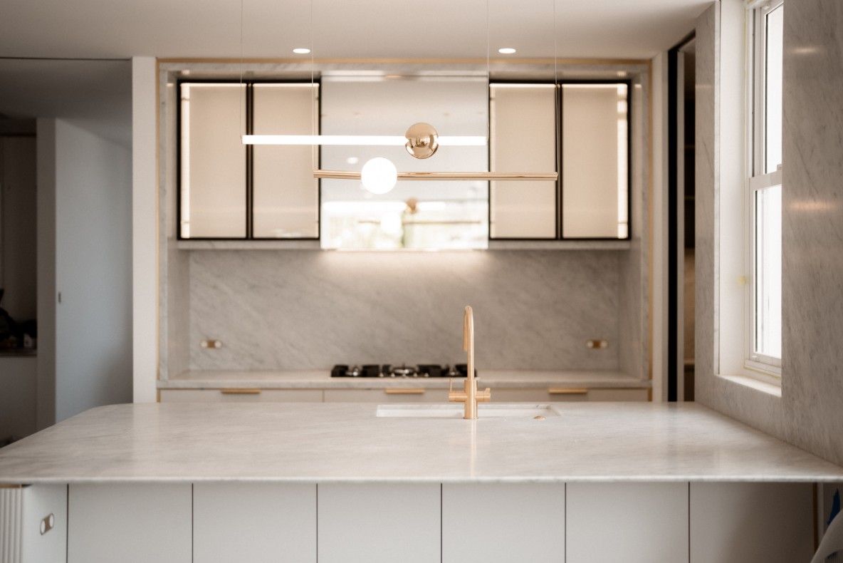 A Kitchen With White Cabinets, a Sink, a Stove and a Window — John McEwan Electrical in Woonona, NSW