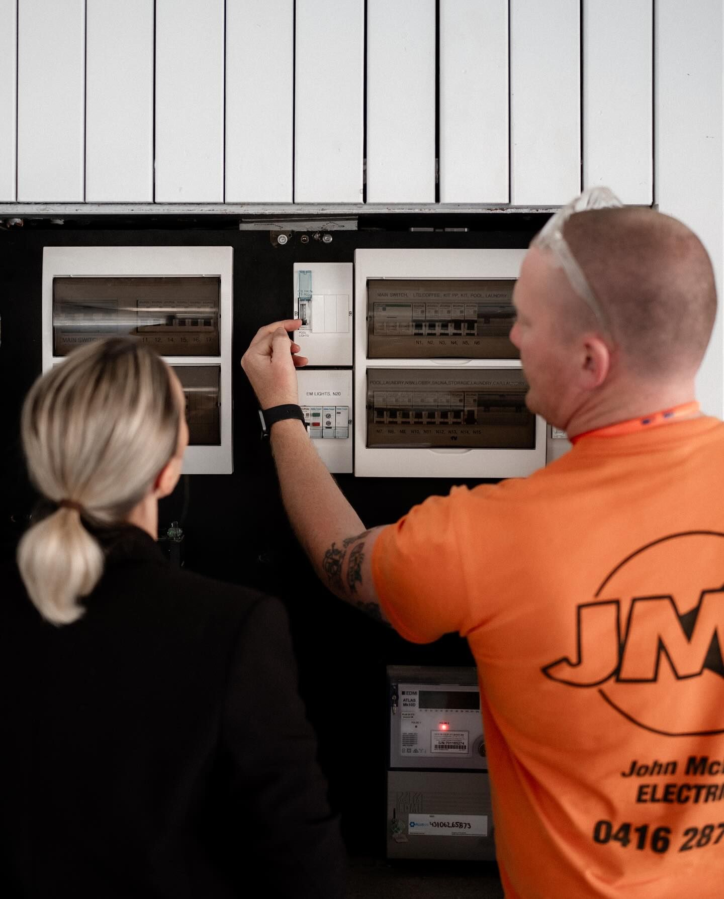 electrician showing woman a fuse box