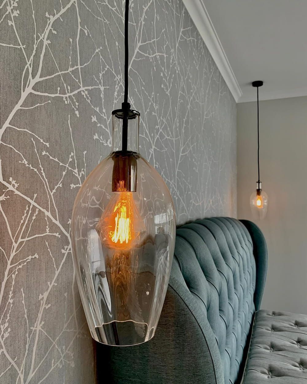 A Pendant Light Is Hanging From The Ceiling In A Bedroom Next To A Bed — John McEwan Electrical in Dapto, NSW