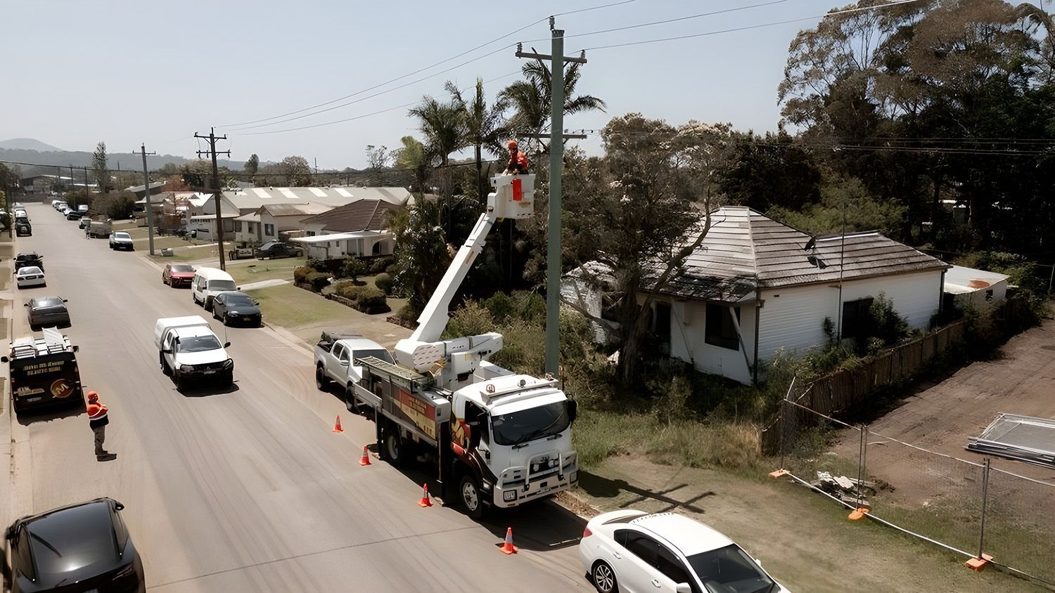 A Level 2 Electrical Service Crew Uses A Bucket Truck To Work On Overhead Power Lines