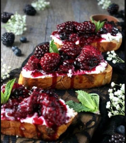 Three slices of bread with berries on them on a table