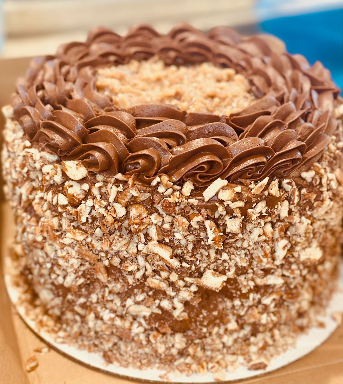 A chocolate cake with nuts on top is sitting on a table.