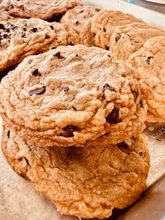 A tray of chocolate chip cookies stacked on top of each other on a table.