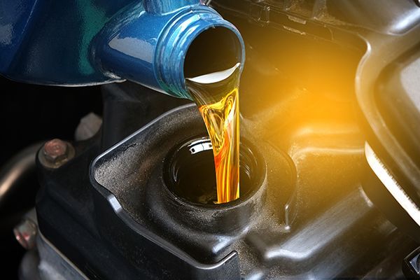 Motor oil being poured into a car engine, highlighting a service process.