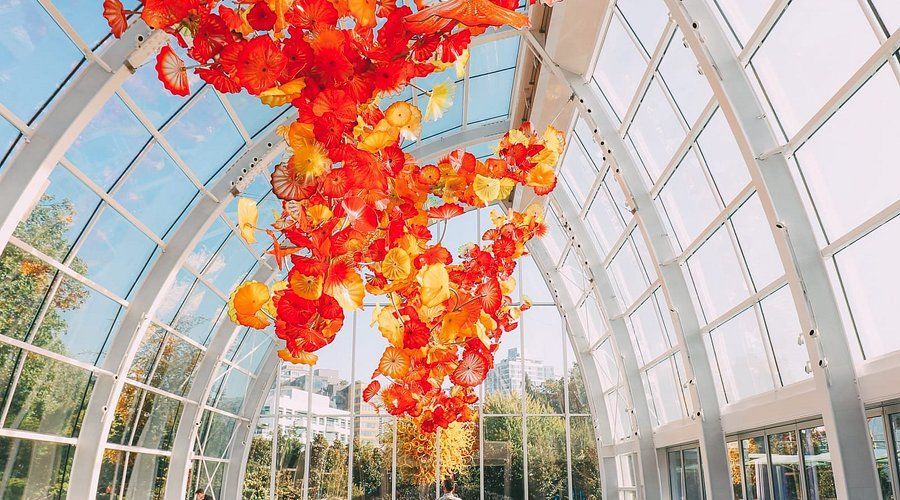 A large glass sculpture is hanging from the ceiling of a building.