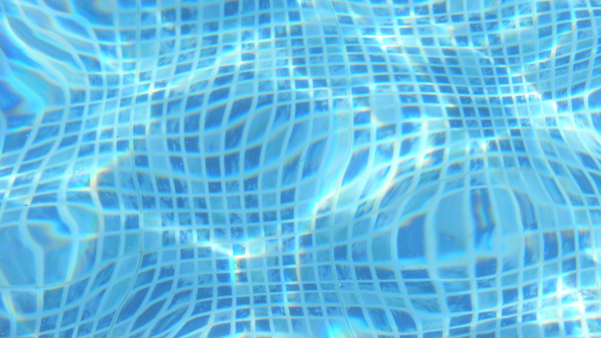 A large white house with a large swimming pool in front of it