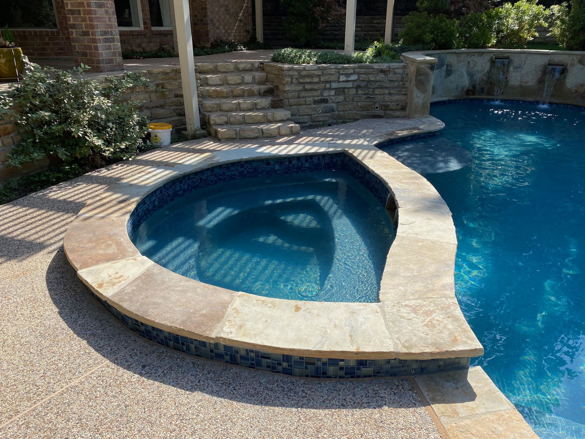 A swimming pool with a hot tub in the middle of it