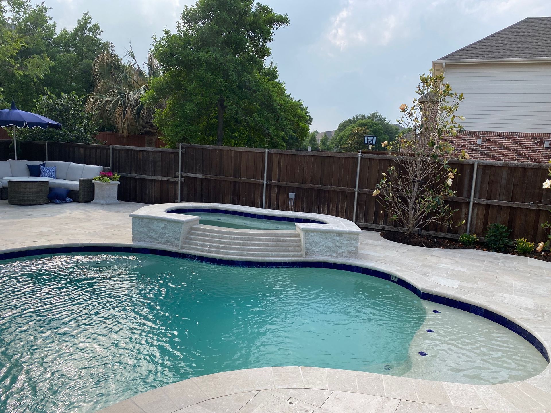 A large swimming pool is surrounded by a wooden fence.