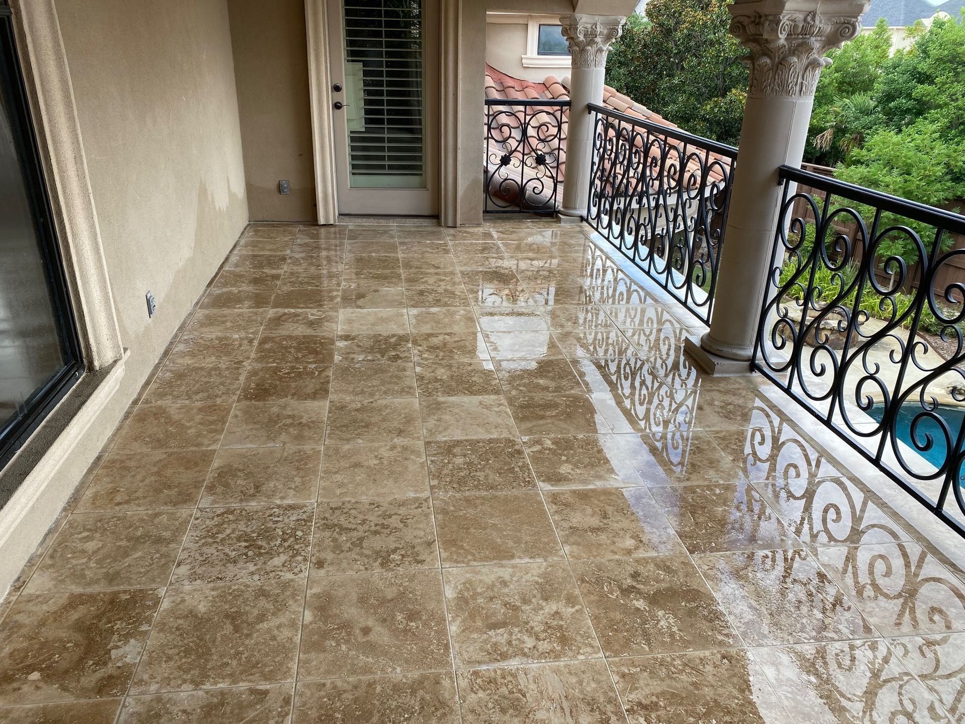 A balcony with a marble floor and a wrought iron railing