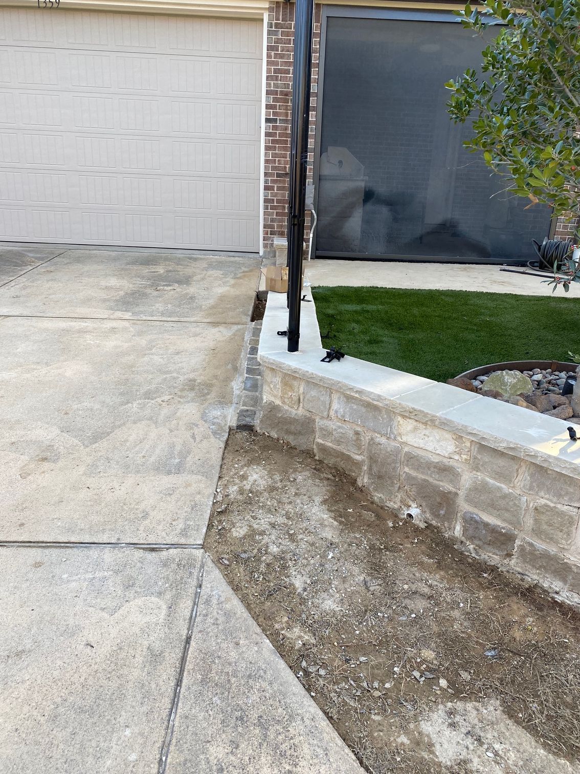 A brick wall is being built in front of a house.