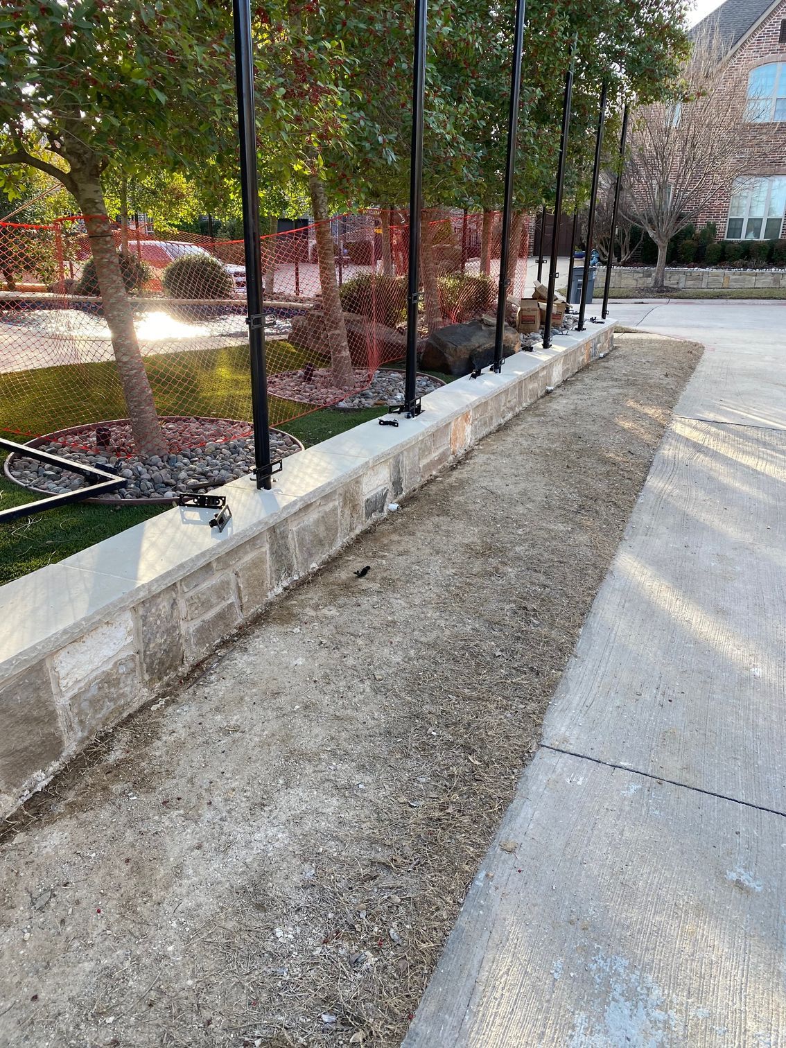 A concrete walkway with a brick wall along the side of it.